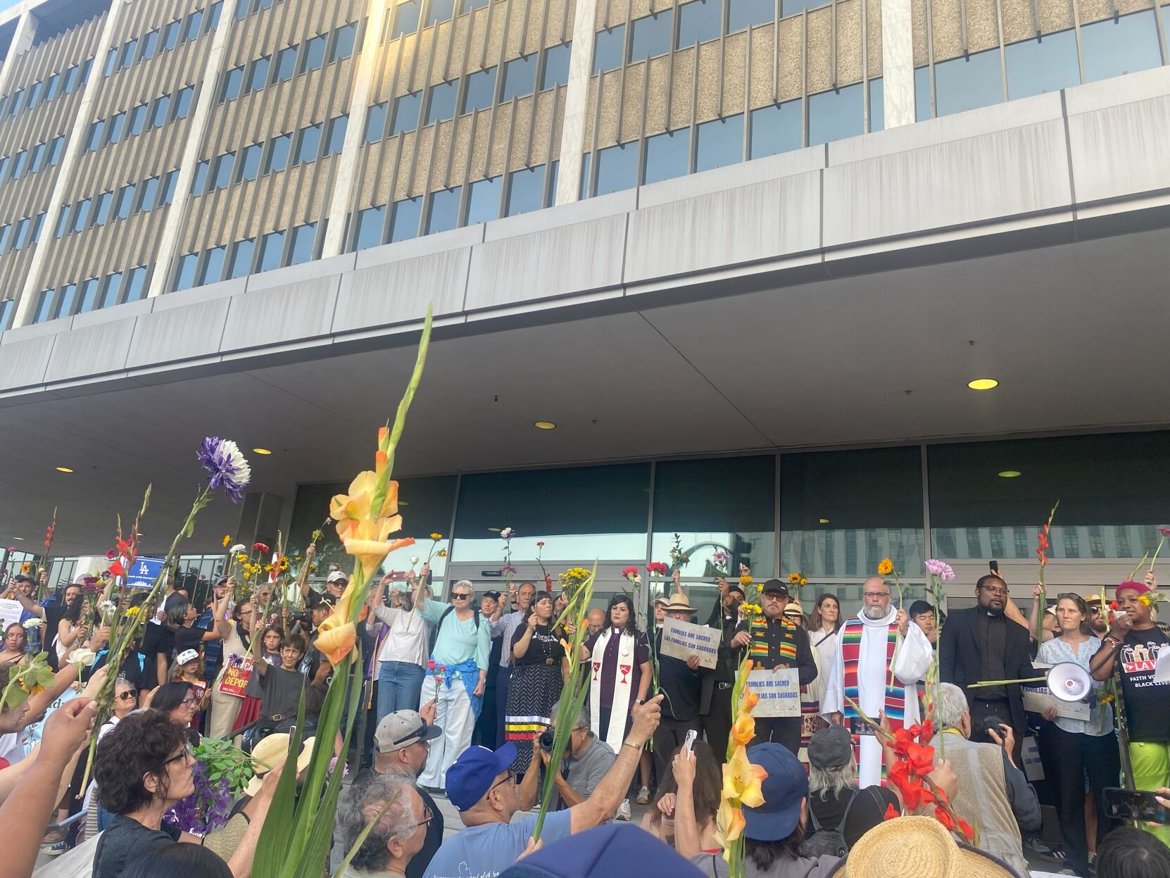 Attendees raise their flowers in prayer at the federal building.jpg